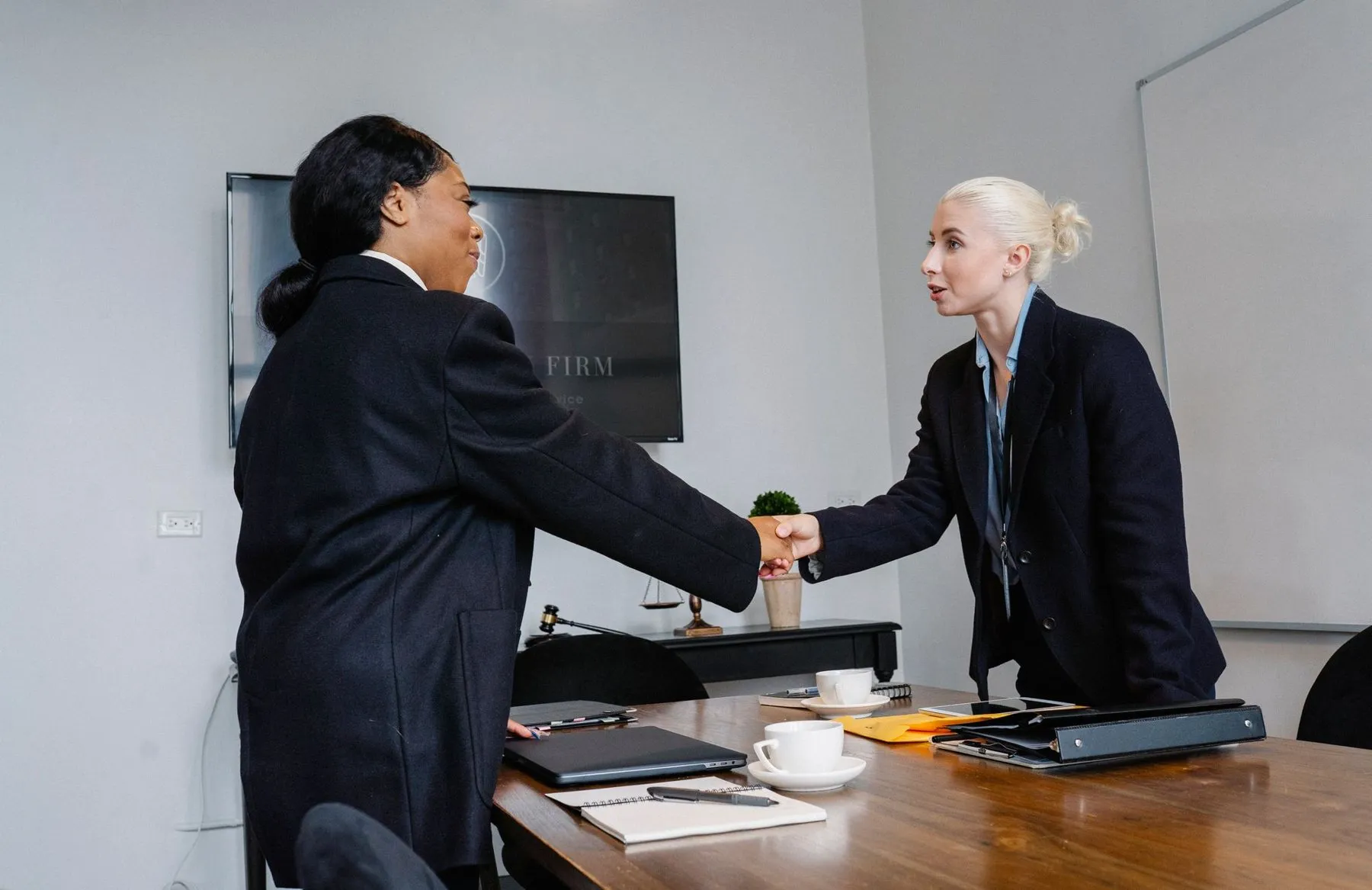 Two professionals shaking hands in an office