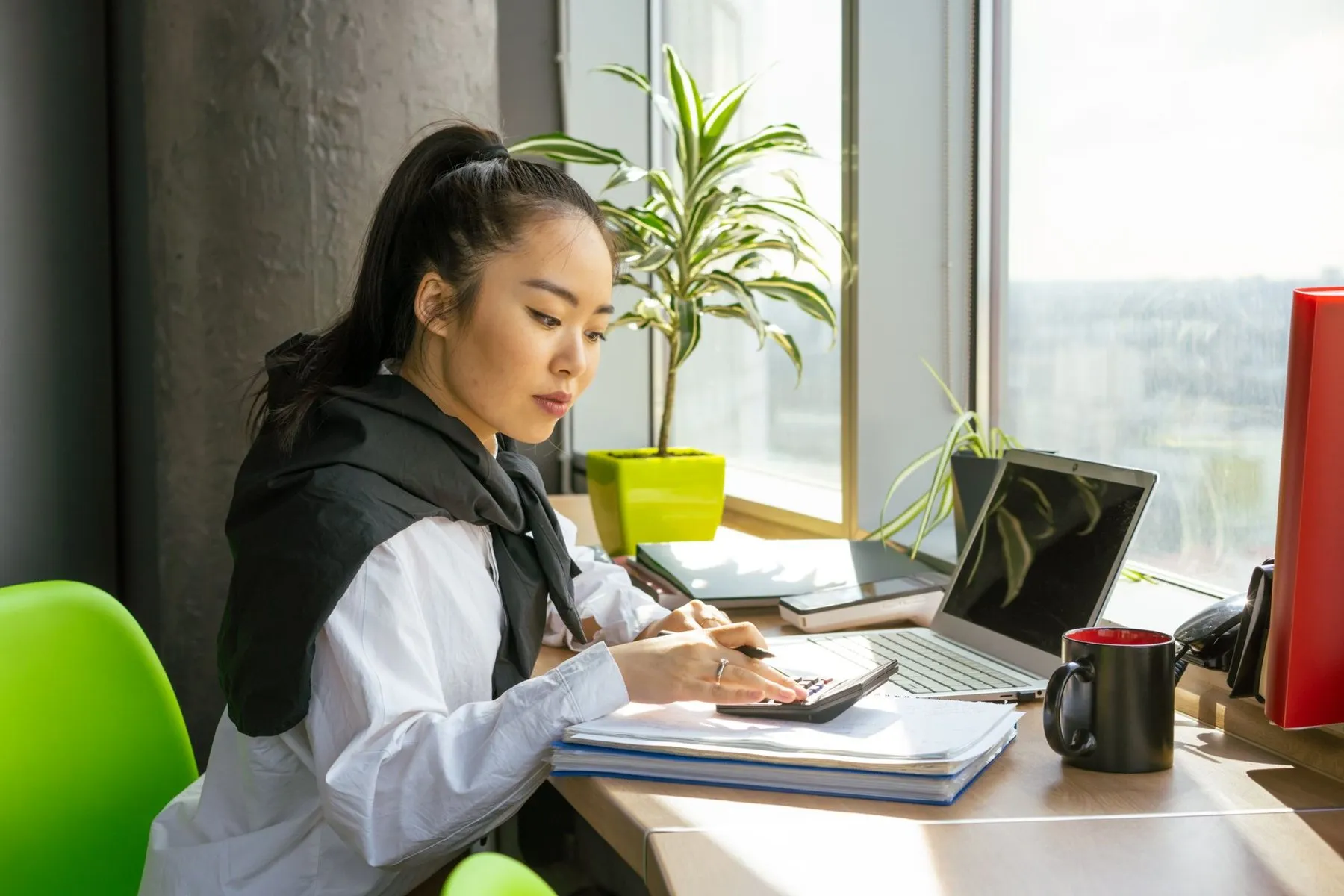 Billing specialist working through paperwork by a bright window