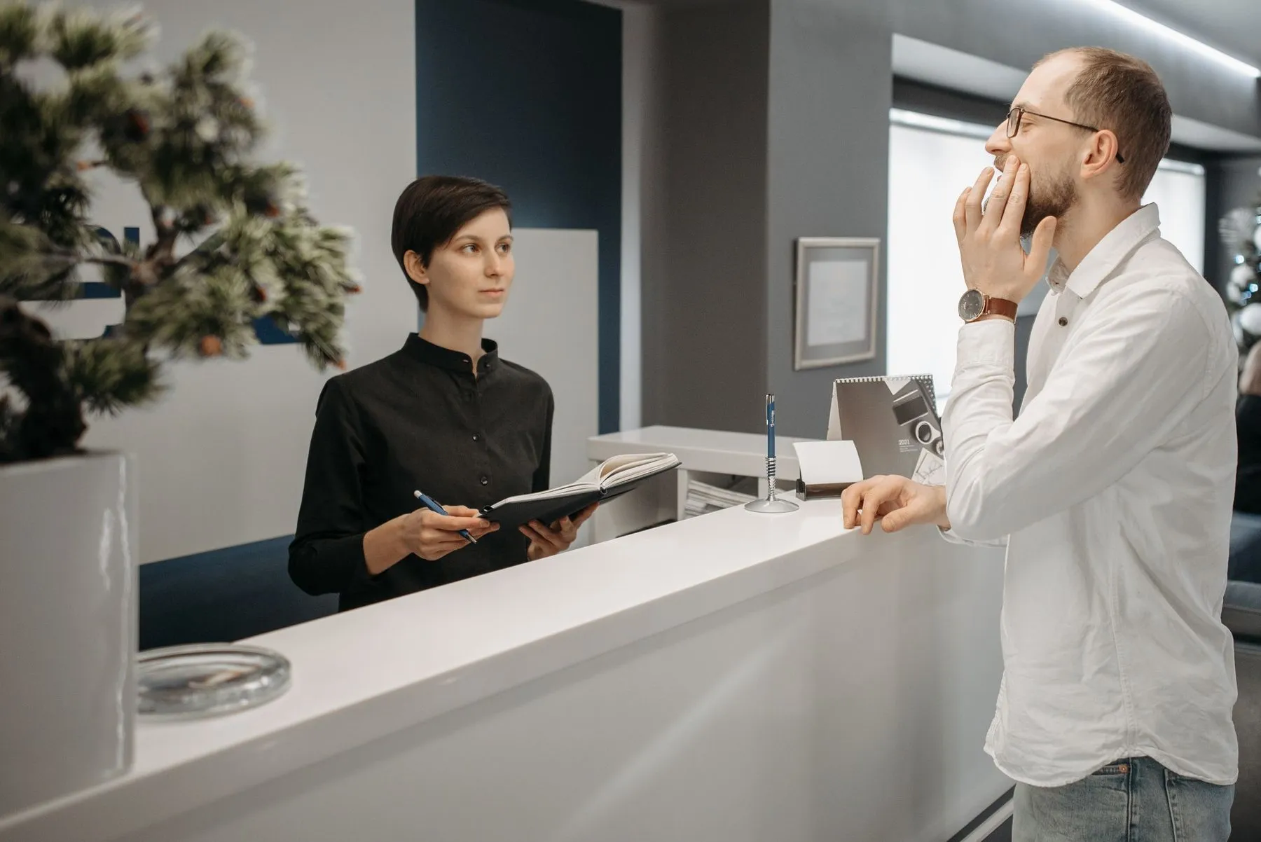 Clinic administrator helping a patient at the front desk