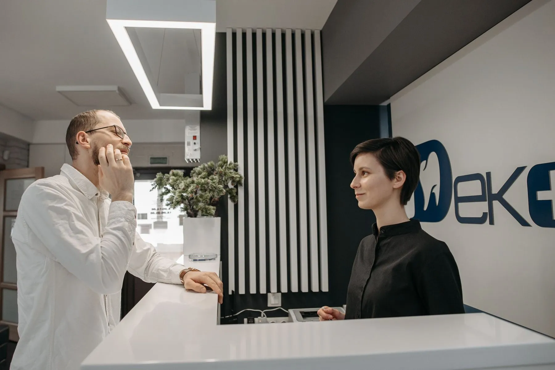 Front-desk coordinator assisting a patient at a dental clinic