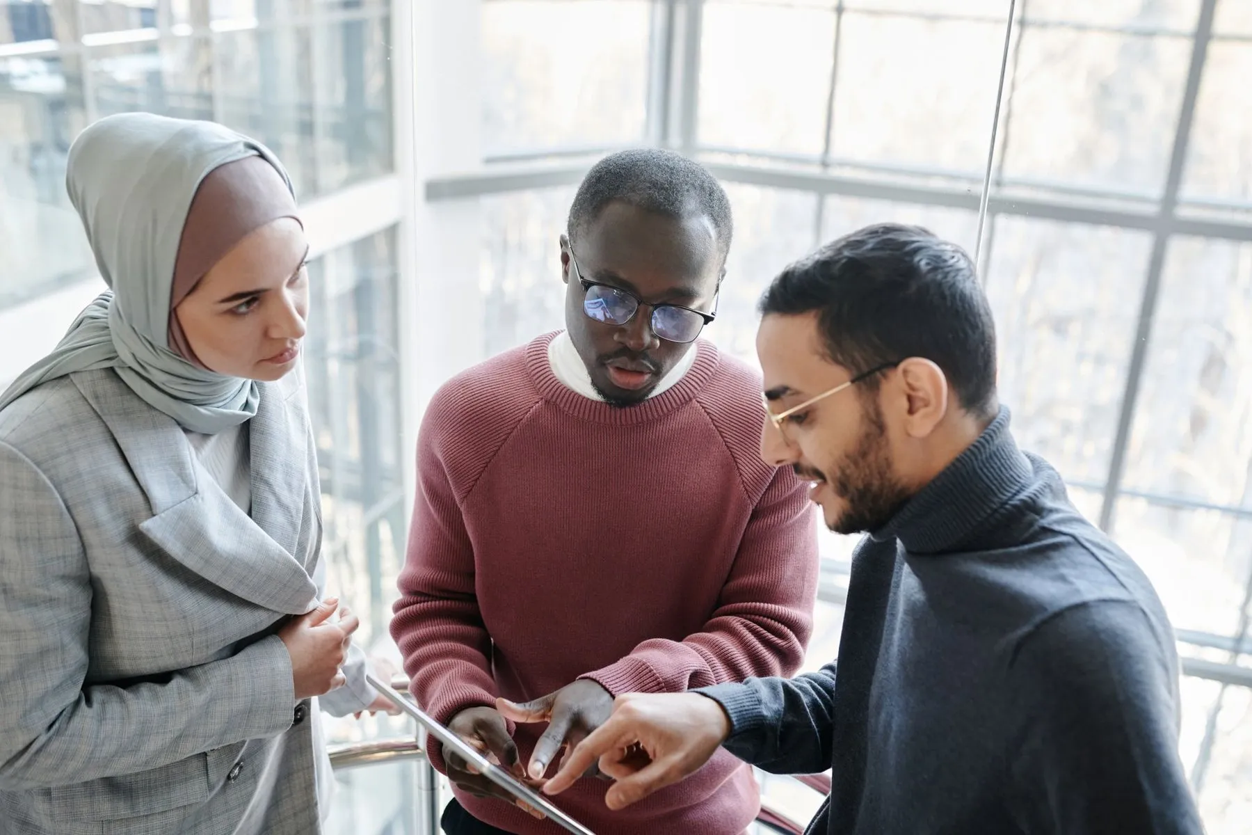 Team reviewing work together on a tablet in a bright office