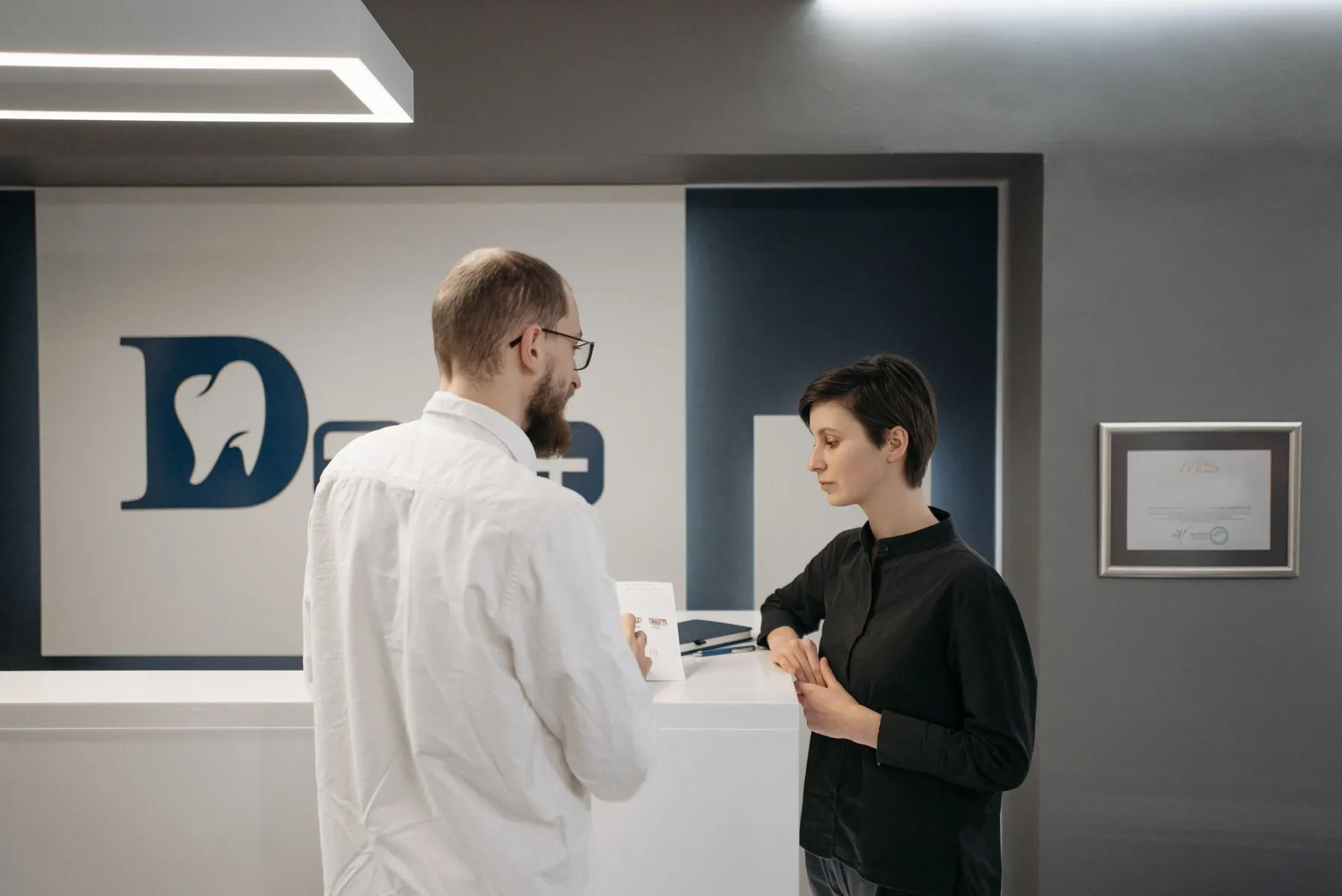 Dentist speaking with a patient at the clinic reception